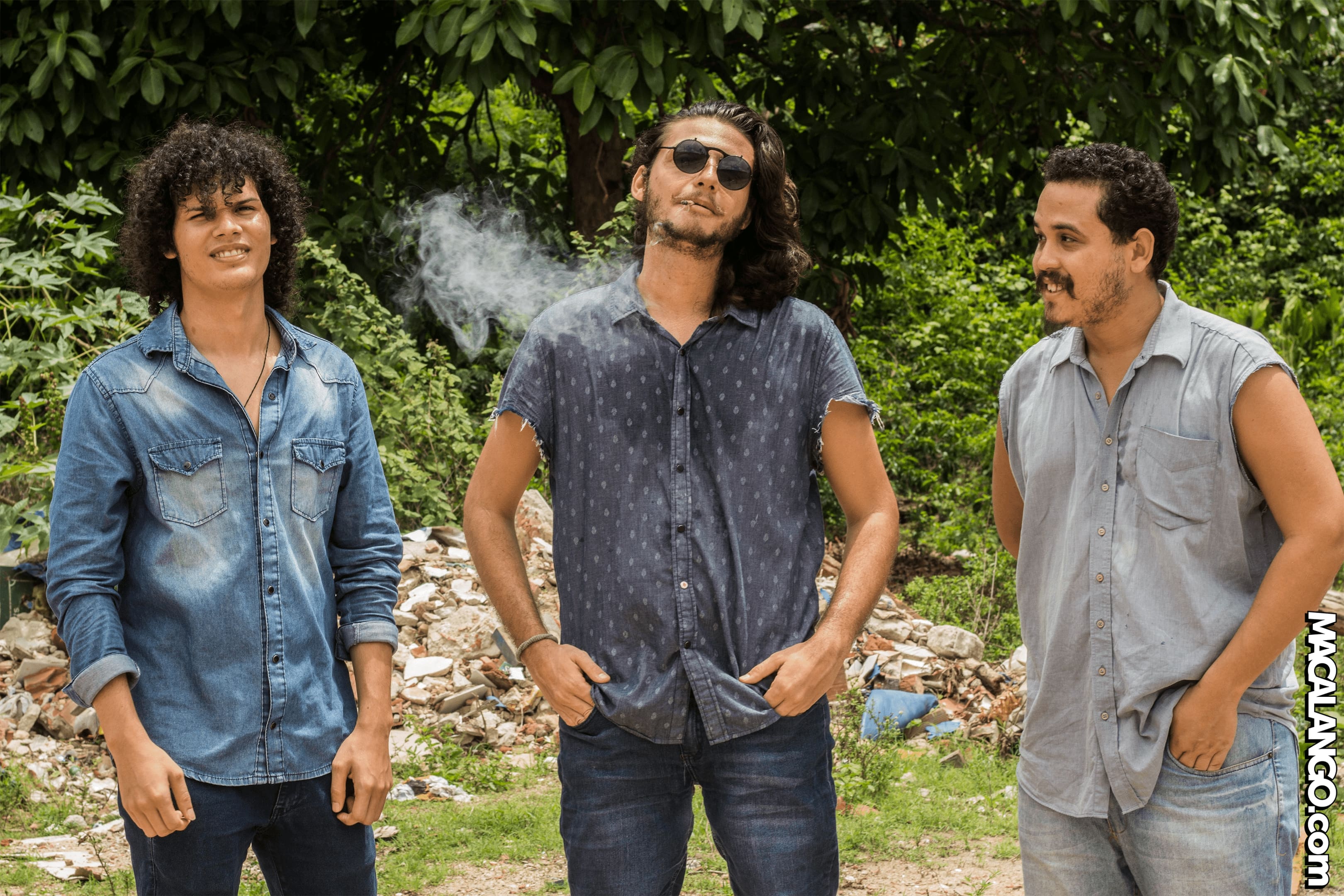 a banda posa no meio da Mata do Buraquinho, com o vocalista segurando uma Jaca